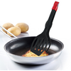 Poêle noire antiadhésive avec un morceau plat doré d'aliment soulevé par une spatule noire fendue au manche rouge ; trois pommes de terre en arrière-plan sur un fond blanc