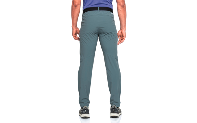 Rückenansicht einer Person mit blauem T-Shirt, graugrünen Hosen, schwarzem Gürtel und schwarz-weißen Sportschuhen, stehend