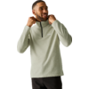 Man in light sage-green fleece pullover with short zipper, hands at collar, smiling