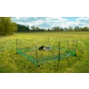 Green mesh fence with metal posts on a meadow, inside two small black animals next to a round gray bowl