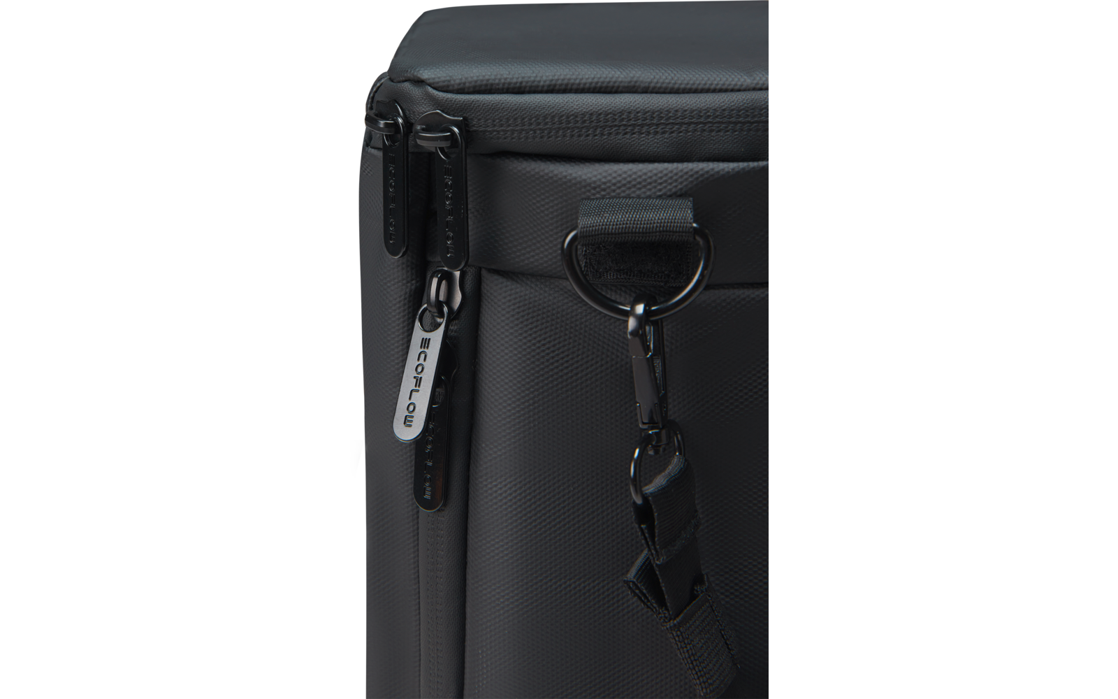 Close-up van een donkergrijze tashoek met twee ritstrekkers, een D-ring en een karabijnhaak aan de schouderriem