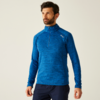 Mann mit dunklem Bart trägt blauen Pullover vor hellem Hintergrund