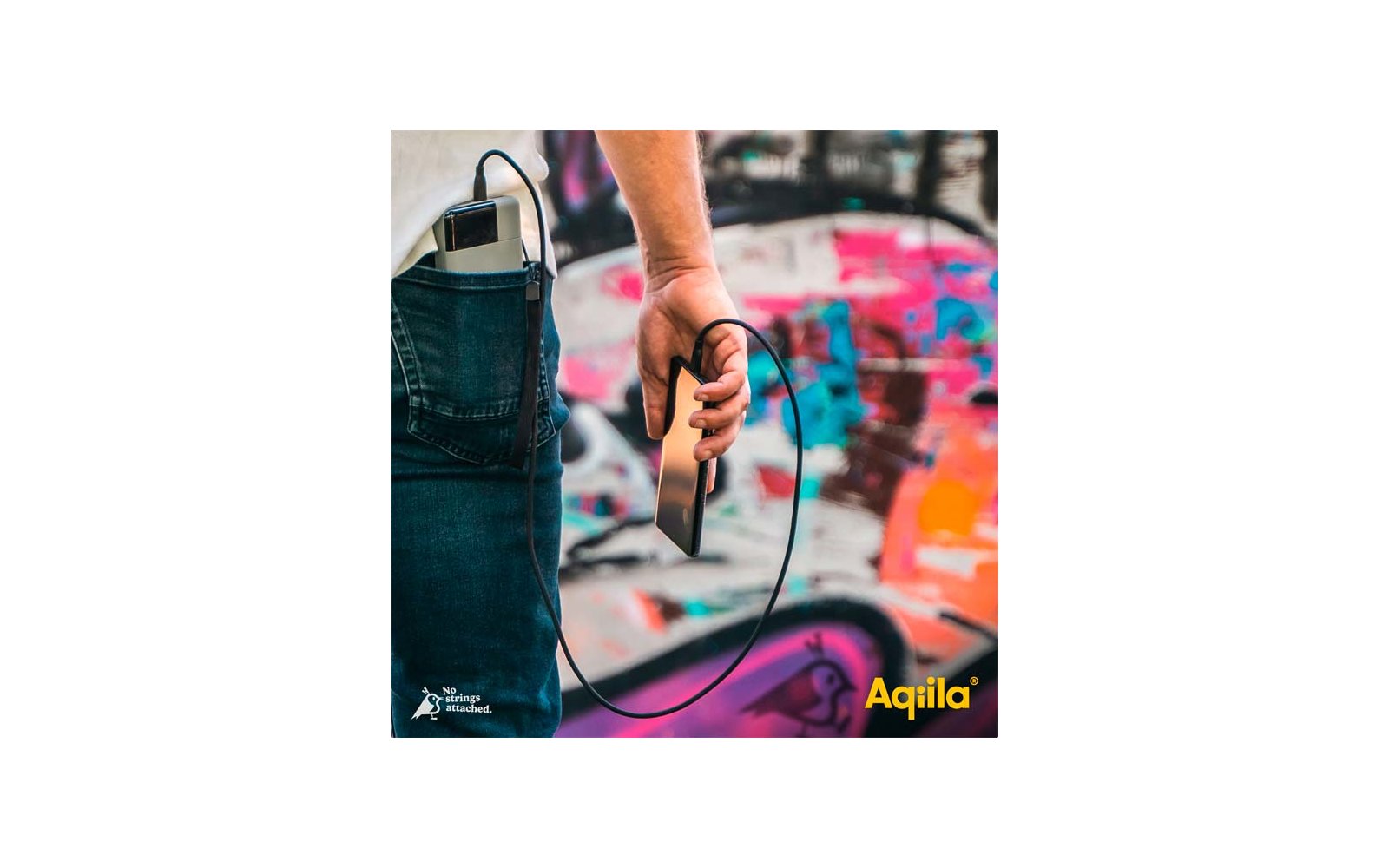 Hand hält eine Fernbedienung mit Kabel vor einem bunten Graffiti-Hintergrund