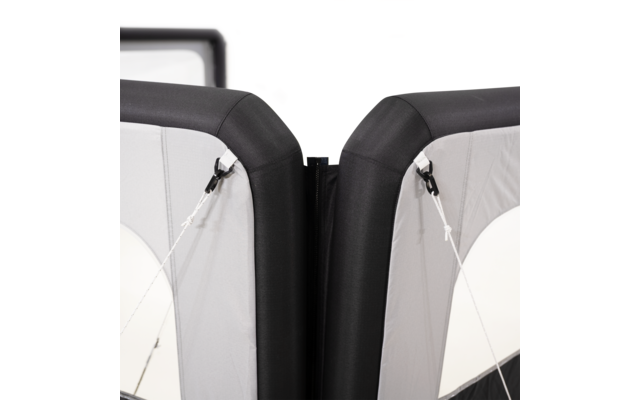 Zwei nebeneinander stehende Polster mit schwarzem Rand und grauen Stoffflächen, in der Mitte ein schmaler Spalt; an den Seiten weiße Spannseile mit schwarzen Clips