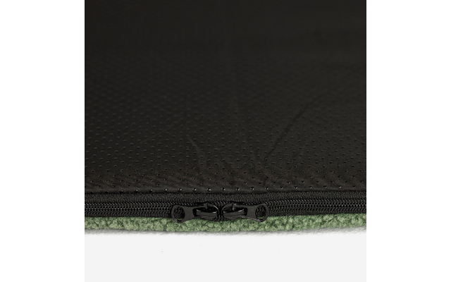 Nahaufnahme eines schwarzen Reißverschlusses an perforiertem schwarzem Stoff über grünem Fleece vor weißem Hintergrund
