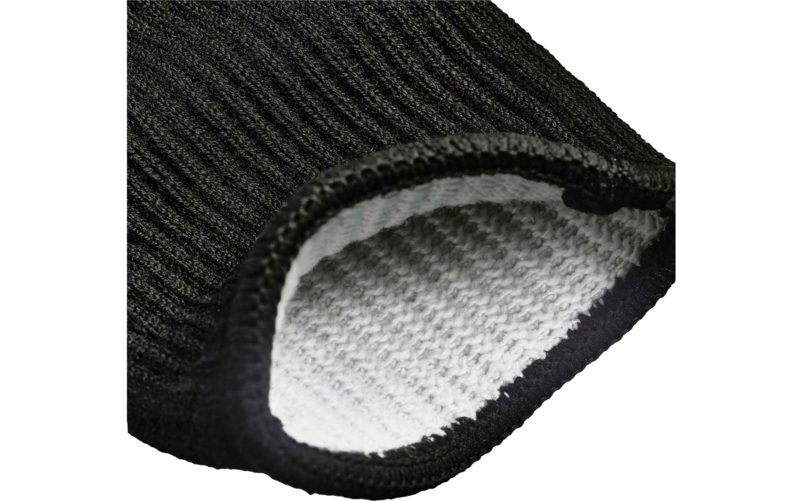 Gros plan d'un tissu tricoté noir côtelé avec bord replié, doublure intérieure blanche à texture gaufrée visible