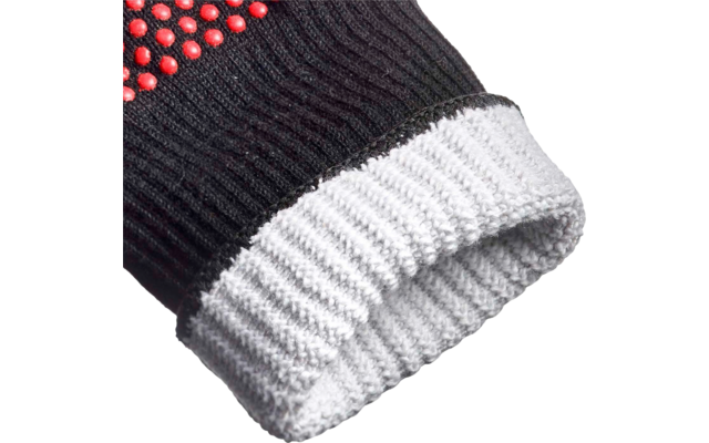 Gros plan d'un gant en tricot noir avec des picots rouges en caoutchouc et un poignet côtelé blanc