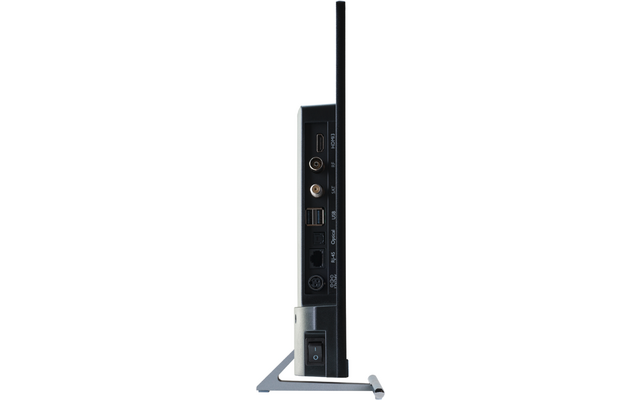 Seitenansicht eines schlanken schwarzen Geräts auf silbernem Stand; sichtbare Anschlussbuchsen an der Seite: HDMI, Koaxialanschluss, zwei USB‑Ports, optischer Audioanschluss und Netzschalter unten