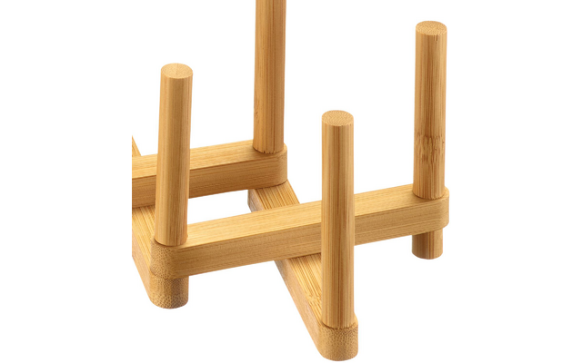 Primo piano di una struttura in bambù marrone chiaro con montanti cilindrici verticali e listelli orizzontali su sfondo bianco