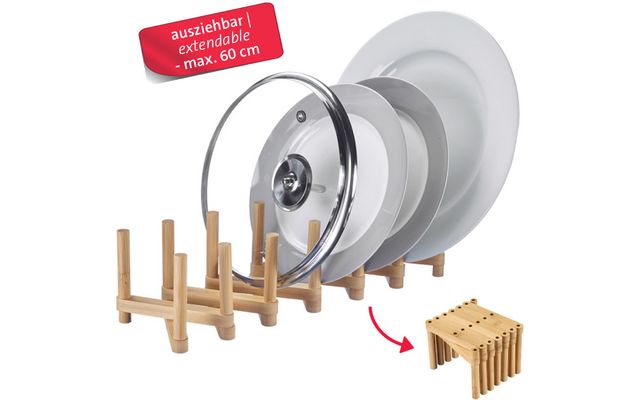Portastoviglie in bambù con perni verticali; quattro padelle/piatti bianchi e un coperchio in vetro in posizione verticale; etichetta rossa con scritto 'ausziehbar | extendable - max. 60 cm'; freccia indica una piccola immagine del porta ripiegato