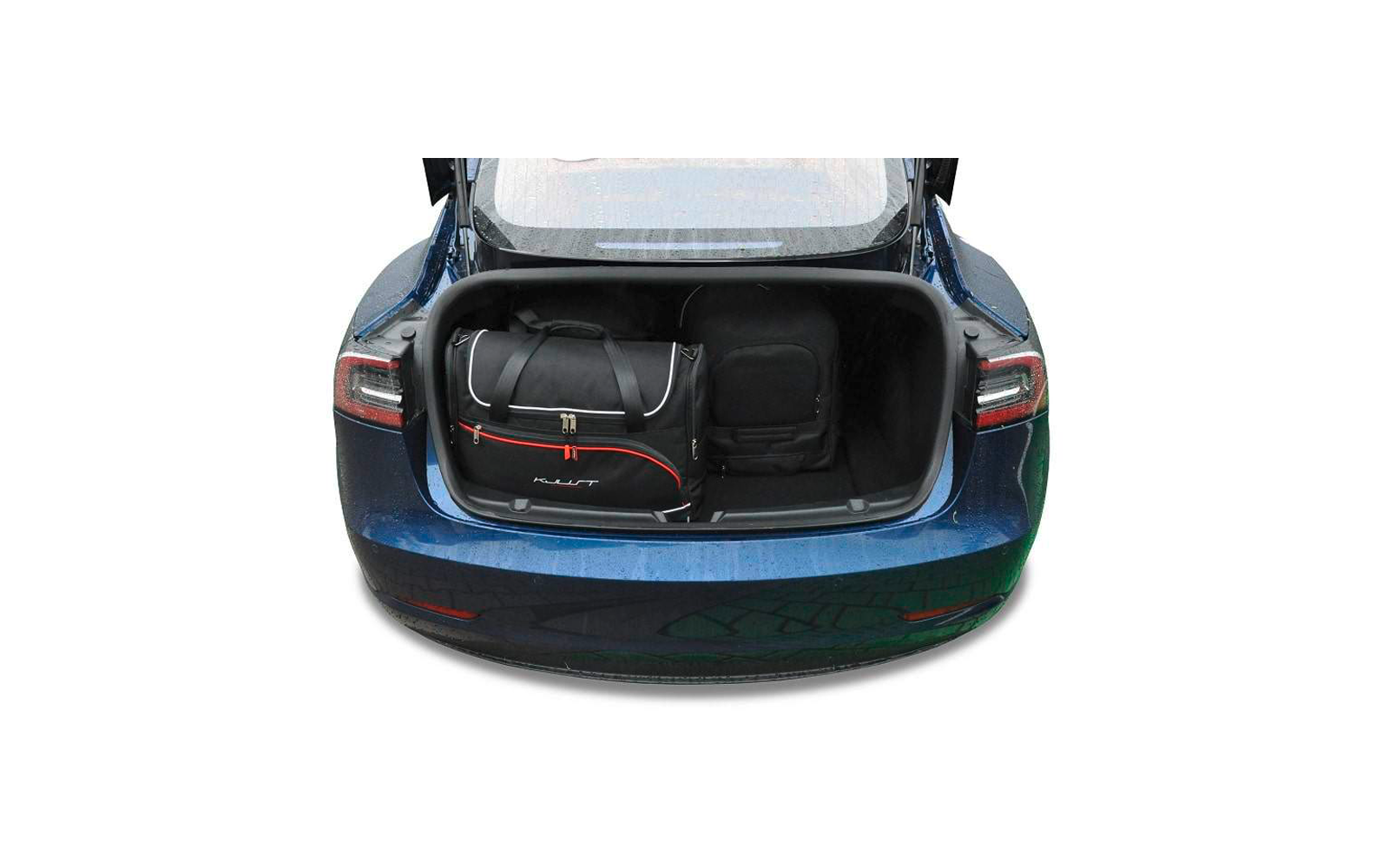 Coffre ouvert d'une voiture bleue avec à gauche un sac de voyage noir avec des accents rouges et à droite un sac à dos noir