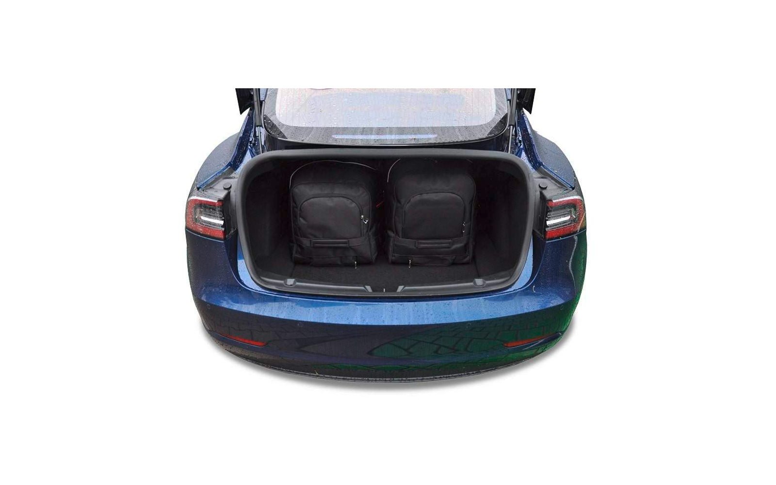 Coffre ouvert d'une voiture bleue avec deux sacs à dos noirs à l'intérieur