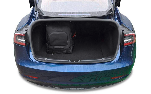Coffre ouvert d'une voiture bleue avec un sac à dos noir à l'intérieur, côté gauche