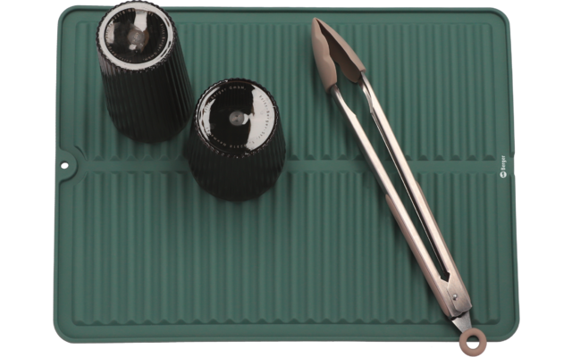 Ein Tintenfass mit Feder auf einer grünen Schreibunterlage