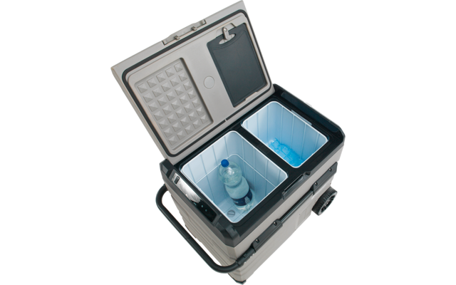 Offene, zweigeteilte Kühlbox mit einer stehenden Plastikflasche in einem Fach und blauen Kühlakkus im anderen; Griff und Räder sichtbar