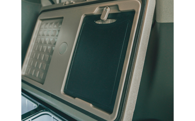 Eingeklappter Tablettentisch an der Rückenlehne eines Sitzes mit Verriegelung und strukturiertem Panel