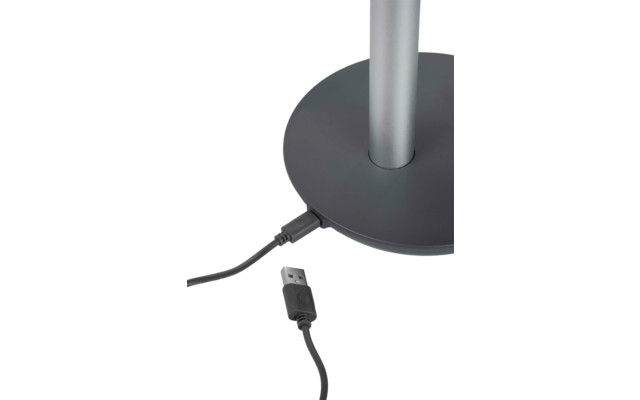 Base ronde foncée avec une tige métallique verticale argentée ; un câble USB noir est branché dans la base, le connecteur USB-A repose à côté, débranché