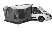 Camper bianco con annesso/telo grigio fissato, tre finestre scure e tiranti verde lime