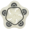 Weißes, blumenförmiges Kunststoffobjekt mit fünf abgerundeten Ausbuchtungen, schwarzem fünfseitigem Innenrand und mehreren kleinen runden Löchern
