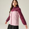 Fille aux cheveux foncés jusqu'aux épaules, porte une veste à capuche bicolore (haut magenta foncé, bas rose clair) avec fermeture éclair et poches latérales, jupe noire, debout devant un fond uni clair et regardant sur le côté