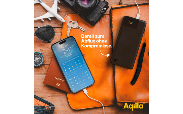 Smartphone met vergrendelscherm, naast een zonnebril, camera, pen en oplader op een oranje achtergrond