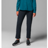 Personne porte un chemisier bleu, pantalon noir et chaussures noires, debout devant un fond gris