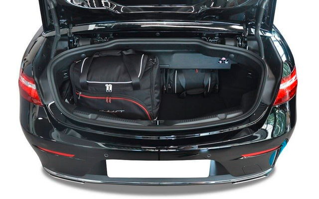 Coffre ouvert d'une voiture noire contenant deux sacs de voyage noirs