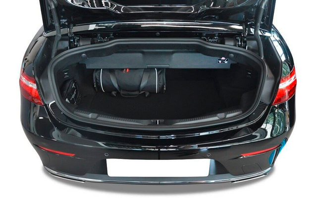 Coffre ouvert d'une voiture noire avec un sac à dos noir à l'intérieur, feux arrière et plaque d'immatriculation blanche visibles