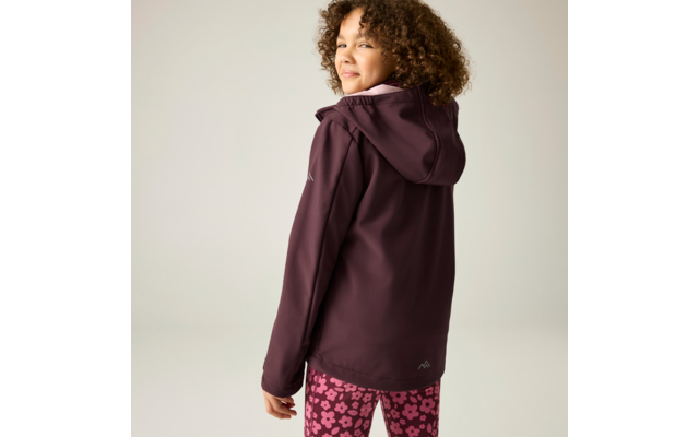 Person von hinten, schaut über die Schulter zur Kamera, trägt dunkelviolette Kapuzenjacke und pinke Leggings mit Blumenmuster, heller einfarbiger Hintergrund