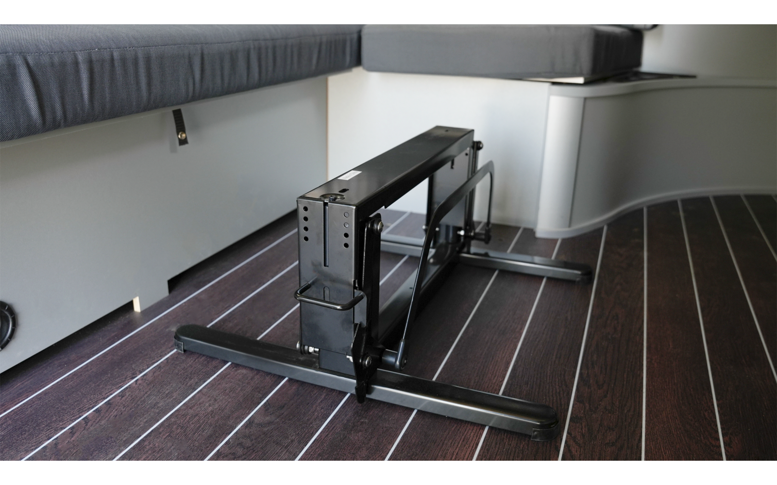 Ein Raum mit einem schwarzen Heizkörper an der Wand und dunkelbraunem Holzfußboden