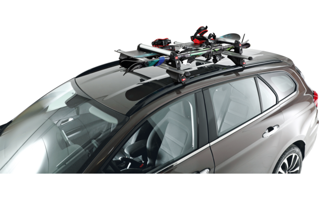 Station wagon con portapacchi sul tetto e sopra due paia di sci e due bastoncini da sci