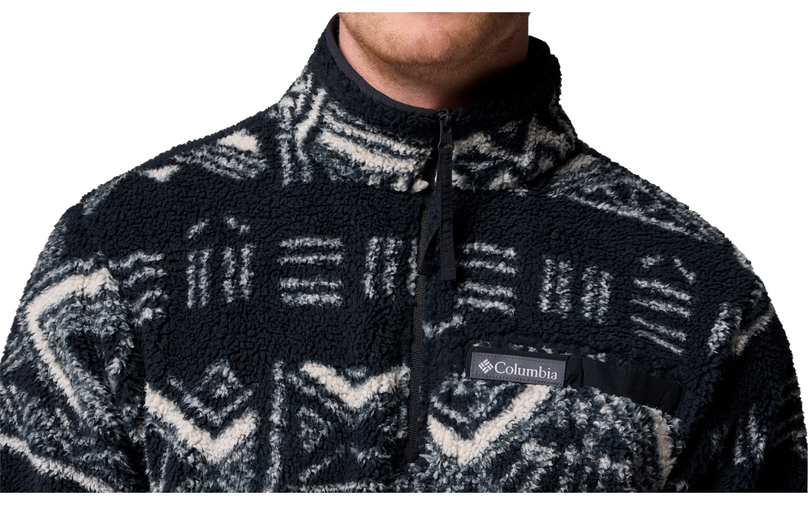 Oberkörper einer Person mit einem dunklen Pullover mit geometrischem Muster