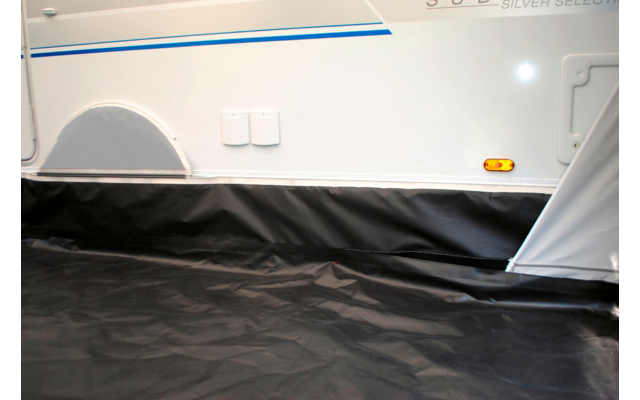 Teil eines Fahrzeugs mit weißer Außenwand, schwarzen Abdeckungen und einem grauen Stoffboden