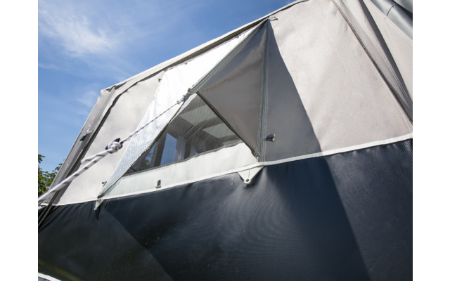 Nahaufnahme eines grauen Zelts mit offenem Fenster bei blauem Himmel