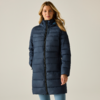 Persona con capelli biondi fino alle spalle che indossa un cappotto imbottito blu scuro fino al ginocchio con zip completa, mani nelle tasche, sfondo chiaro uniforme