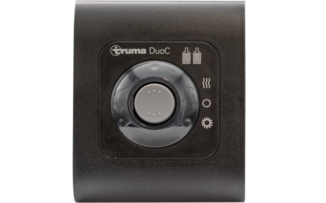 Schwarzes rechteckiges Gerät mit dem Schriftzug "Truma DuoC" oben, großer runder Drehknopf in der Mitte mit grauem Zentralknopf und transparenter Umrandung, Symbole rechts: zwei Gasflaschen, drei Wellenlinien, Kreis, Zahnrad
