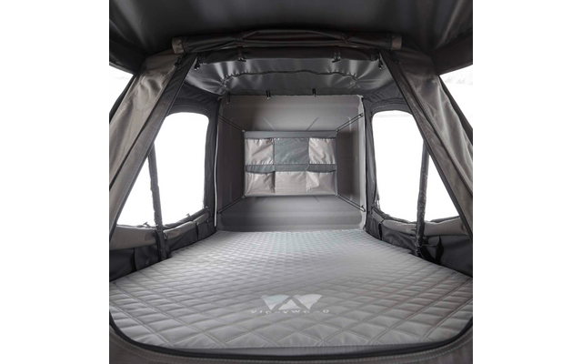 Innenraum eines grauen Zeltes mit gesteppter Matratze, seitlichen Fenstern und Rückwand mit Aufbewahrungstasche