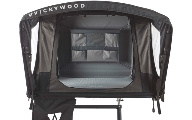 Offenes schwarzes Dachzelt auf Gestell, graues Matratzelement im Inneren sichtbar, Rückwand mit drei Fächertaschen, Schriftzug "VICKYWOOD" an der oberen Blende