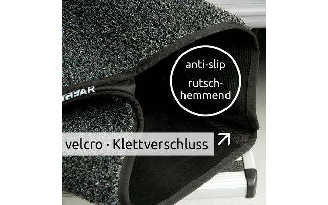 Nahaufnahme eines grauen, strukturierten Teppichstücks mit schwarzem Klettverschluss auf einer Metallstufe; sichtbare Texte 'anti-slip rutschhemmend' und 'velcro · Klettverschluss'