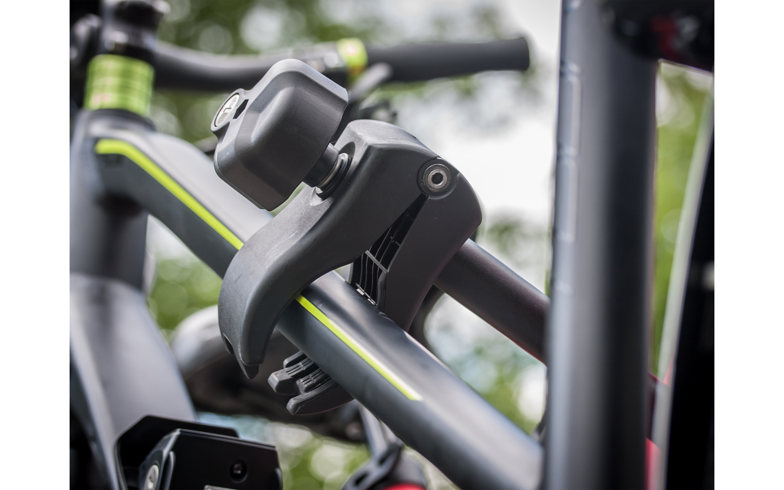 Nahaufnahme eines schwarzen Fahrradrahmens mit gelbgrünem Streifen und einer schwarzen Kunststoffklemme