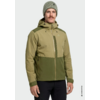 Personne portant une veste d'extérieur olive et vert foncé avec capuche et fermeture éclair frontale, bonnet vert rayé, moustache, pantalon noir, fond clair