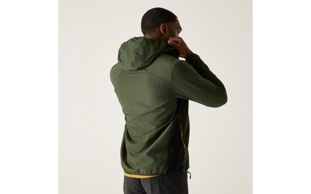 Person von hinten zieht die Kapuze einer grünen, strukturierten Jacke hoch; trägt dunkle Sporthose; heller einfarbiger Hintergrund