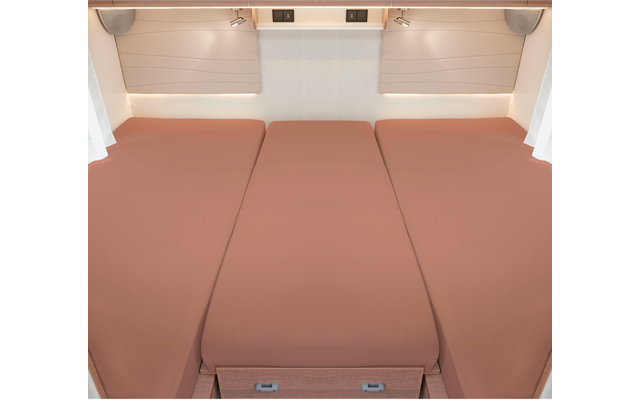 Trois matelas roses côte à côte dans un espace intérieur avec des murs blancs et des stores