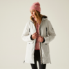 Frau mit rosa Mütze trägt helle Jacke und schwarzen Pullover vor hellem Hintergrund