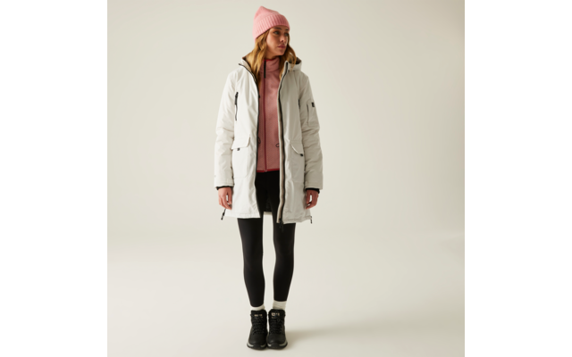 Eine Frau trägt eine weiße Winterjacke, ein rosa Kapuzenpullover, schwarze Leggings und schwarze Stiefel