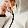 Nahaufnahme einer Person in weißer Jacke mit hochgezogenem Reißverschluss