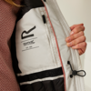 Hand hält die Innenseite einer Jacke mit einem eingenähten Etikett