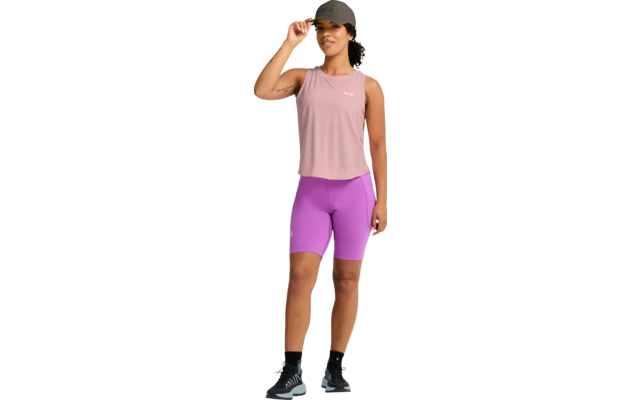 Person in Sportkleidung: rosa ärmelloses Top, violette Radlerhose, graue Kappe, schwarze Sneakers, steht, rechte Hand berührt die Kappenkrempe