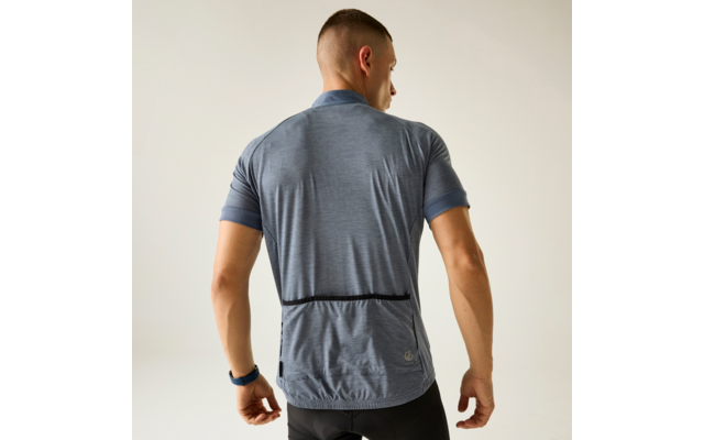 Person von hinten in blauem, kurzärmligem Fahrradtrikot und schwarzen Radhosen vor hellem Hintergrund