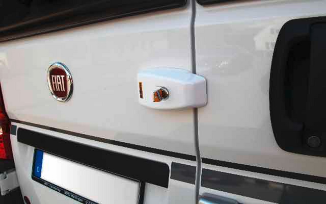 Weiße Fahrzeugseite mit Fiat-Emblem und einem weißen, befestigten Kästchen mit Kabel